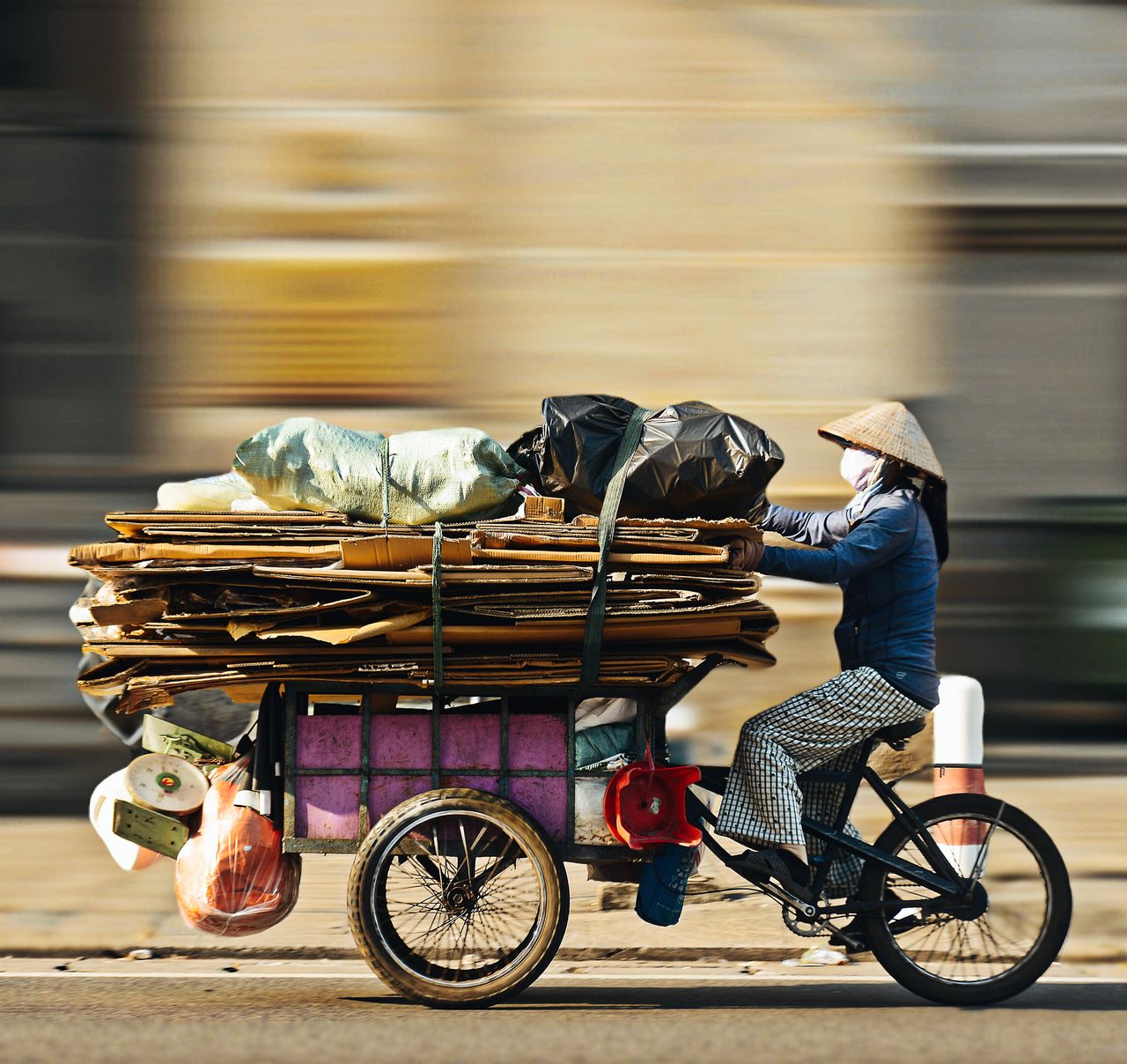 Bicyclist collecting recyclables in Ho Chi Minh City, embodying sustainable living and urban recycling.